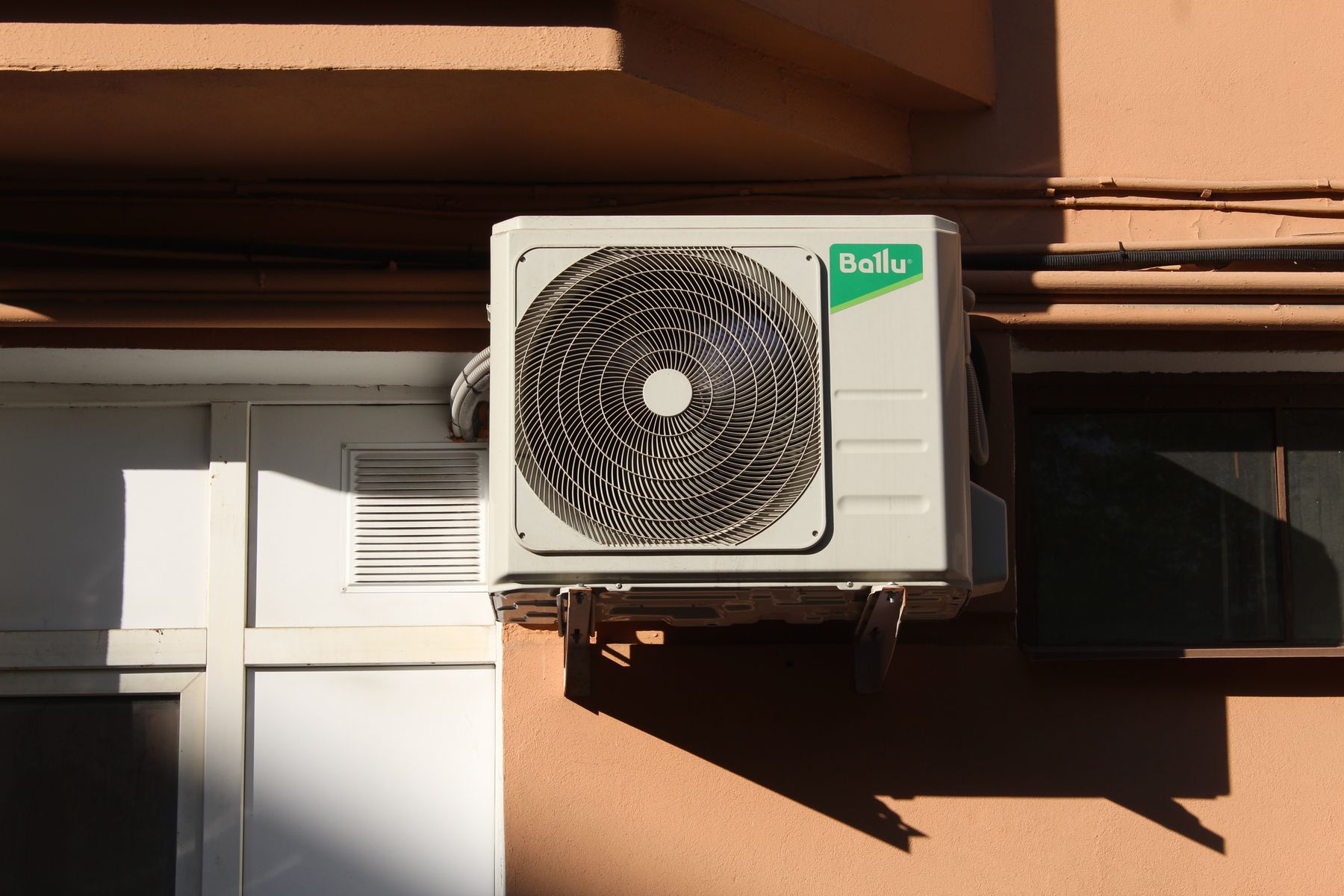 Condensorunit aan de buitengevel van een pand